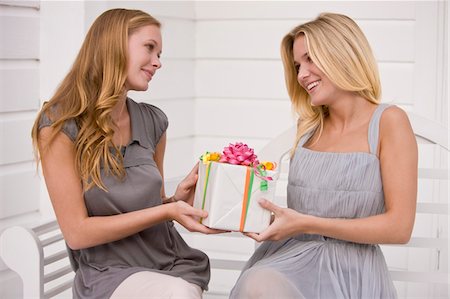 Woman giving a present to her friend Stock Photo - Premium Royalty-Free, Code: 6108-05862685