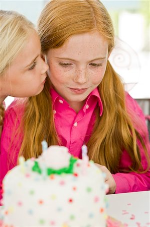 Close-up of a girl celebrating her birthday with her friend Stock Photo - Premium Royalty-Free, Code: 6108-05862693