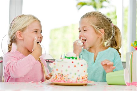 simsearch:6108-05863080,k - Two girls eating birthday cake Foto de stock - Sin royalties Premium, Código: 6108-05862719