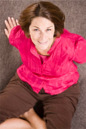 simsearch:6108-05863892,k - Portrait d'une femme assise sur un canapé rond et souriant Photographie de stock - Premium Libres de Droits, Code: 6108-05862869