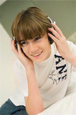 Boy listening to headphones Stock Photo - Premium Royalty-Free, Code: 6108-05862978