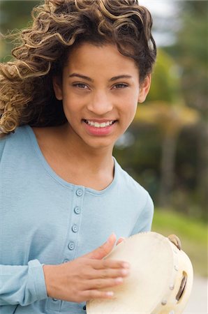 Portrait of a girl playing a tambourine Stock Photo - Premium Royalty-Free, Code: 6108-05862906