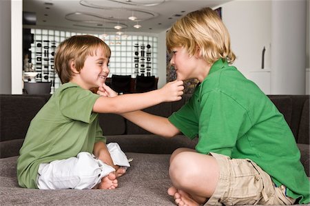 Two boys touching each other's chin and smiling Stock Photo - Premium Royalty-Free, Code: 6108-05863006