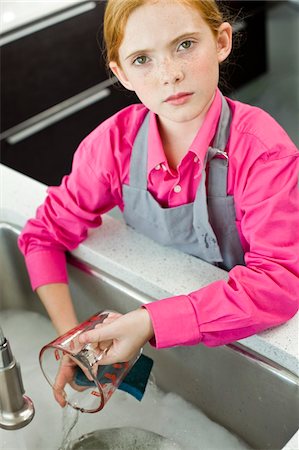 Portrait d'une jeune fille une cruche de mesure à un évier de lavage Photographie de stock - Premium Libres de Droits, Code: 6108-05863015