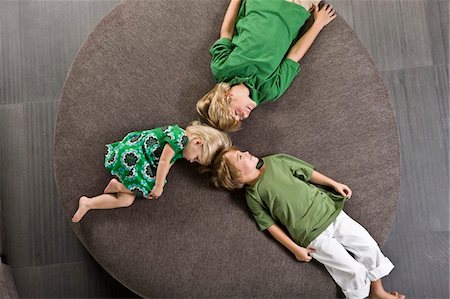 round house - Three friends lying on a round sofa Stock Photo - Premium Royalty-Free, Code: 6108-05863023