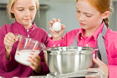 eggs milk - Two girls cooking food in the kitchen Foto de stock - Sin royalties Premium, Código: 6108-05863028