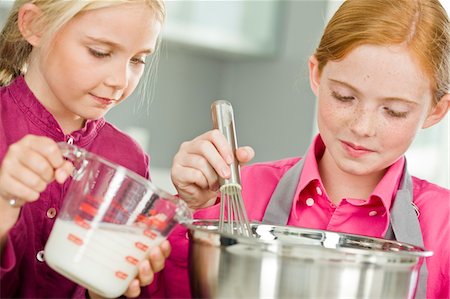 simsearch:6108-05863028,k - Two girls cooking food in the kitchen Stock Photo - Premium Royalty-Free, Code: 6108-05863038