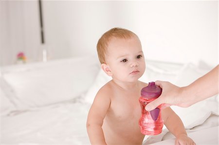 Woman giving a baby bottle to her daughter Stock Photo - Premium Royalty-Free, Code: 6108-05863179