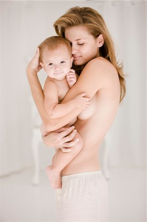 Woman carrying her daughter Stock Photo - Premium Royalty-Free, Code: 6108-05863181