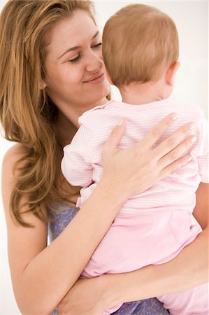 family with back looking out - Woman holding her daughter Stock Photo - Premium Royalty-Free, Code: 6108-05863188