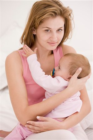 pacifier mom holding - Woman carrying her daughter Stock Photo - Premium Royalty-Free, Code: 6108-05863198