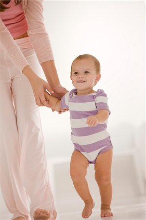 Woman helping her daughter to walk Stock Photo - Premium Royalty-Free, Code: 6108-05863215