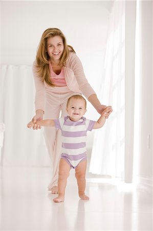 simsearch:6108-05860155,k - Woman helping her daughter to walk Stock Photo - Premium Royalty-Free, Code: 6108-05863218