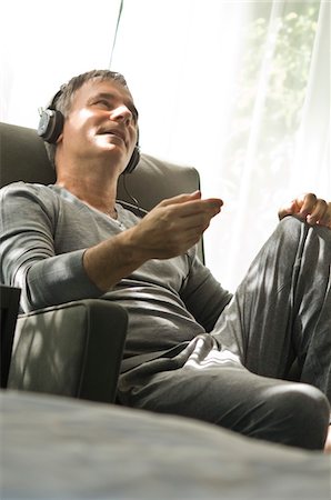 Man listening to music with headphones Stock Photo - Premium Royalty-Free, Code: 6108-05863342