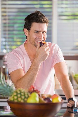 Portrait of a man eating a nectarine Stock Photo - Premium Royalty-Free, Code: 6108-05863303
