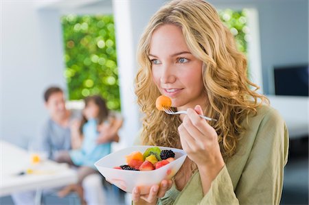 strawberries in salad - Woman eating fruit salad Stock Photo - Premium Royalty-Free, Code: 6108-05863460