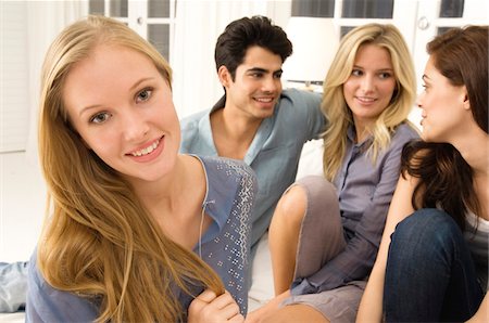 Four friends gossiping in a living room Stock Photo - Premium Royalty-Free, Code: 6108-05863668