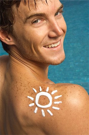 simsearch:6108-05863854,k - Homme en forme de soleil sur son épaule au bord de la piscine Photographie de stock - Premium Libres de Droits, Code: 6108-05863764