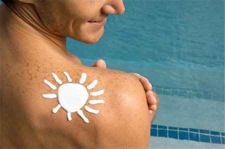 simsearch:6108-05863854,k - Homme en forme de soleil sur son épaule au bord de la piscine Photographie de stock - Premium Libres de Droits, Code: 6108-05863783