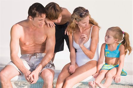 simsearch:6109-08537086,k - Family sitting at the poolside Stock Photo - Premium Royalty-Free, Code: 6108-05863802