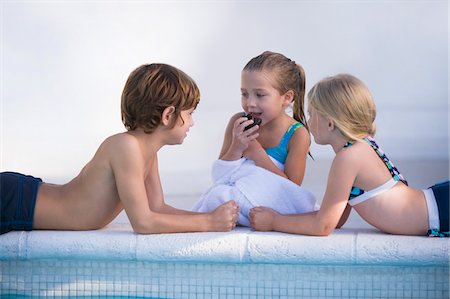 Two girls and a boy at the poolside Foto de stock - Sin royalties Premium, Código: 6108-05863814