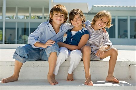 Portrait of three children sitting together Stock Photo - Premium Royalty-Free, Code: 6108-05863838