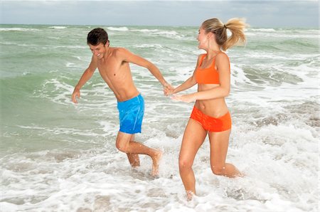 simsearch:6108-05857454,k - Couple running in water on the beach Stock Photo - Premium Royalty-Free, Code: 6108-05863983