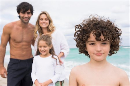 Portrait of a boy with his family in the background Stock Photo - Premium Royalty-Free, Code: 6108-05864042