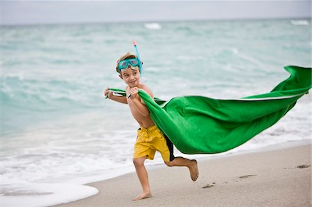 Boy wearing a scuba mask and running on the beach Stock Photo - Premium Royalty-Free, Code: 6108-05864068