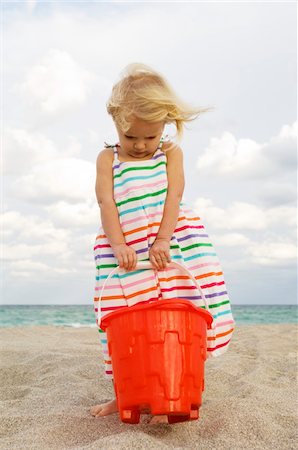 simsearch:6108-05866106,k - Girl holding a sand pail on the beach Stock Photo - Premium Royalty-Free, Code: 6108-05864069