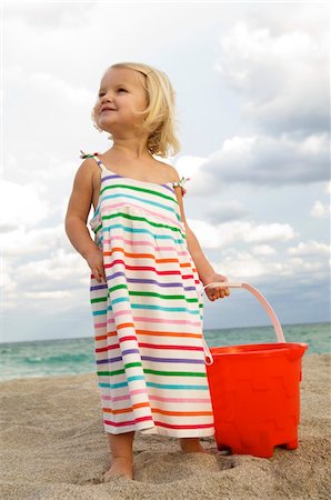 simsearch:6108-05865608,k - Girl holding a sand pail on the beach Stock Photo - Premium Royalty-Free, Code: 6108-05864083