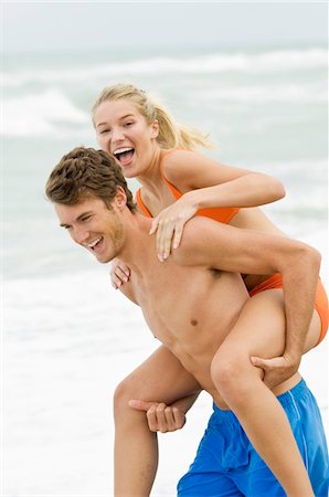 simsearch:614-06898339,k - L'homme qui donne femme piggyback tour sur la plage Photographie de stock - Premium Libres de Droits, Code: 6108-05864001