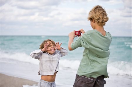 Boy taking his brother's picture with a digital camera Stock Photo - Premium Royalty-Free, Code: 6108-05864120