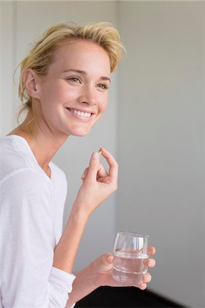 solution (mixture of substances) - Woman taking an Omega-3 capsule Stock Photo - Premium Royalty-Free, Code: 6108-05864395