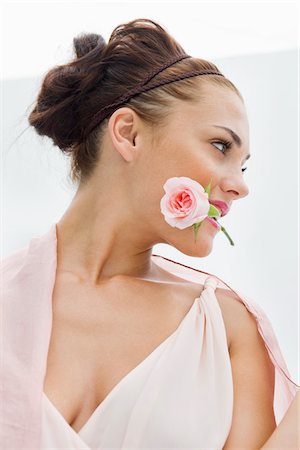 pink, rose, white background - Fashion model holding rose between her teeth Stock Photo - Premium Royalty-Free, Code: 6108-05864300
