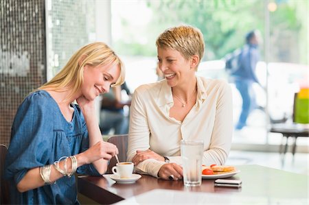 pausa para café - Two women sitting in a restaurant and smiling Foto de stock - Sin royalties Premium, Código: 6108-05864727