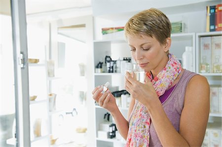 Woman smelling perfume in a store Foto de stock - Sin royalties Premium, Código: 6108-05864737