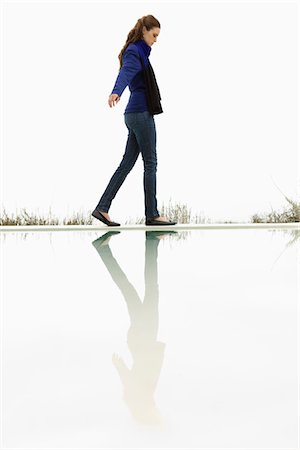 Woman walking at the poolside Stock Photo - Premium Royalty-Free, Code: 6108-05864874
