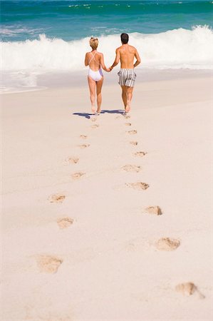 Couple running on the beach Stock Photo - Premium Royalty-Free, Code: 6108-05864891