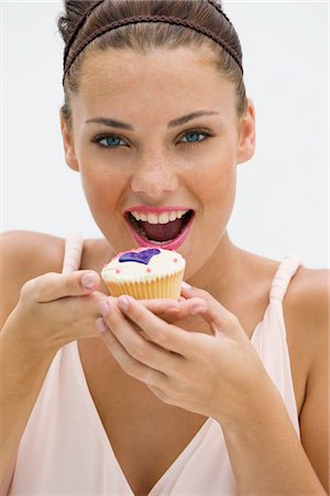 Woman eating a cupcake Foto de stock - Sin royalties Premium, Código: 6108-05864820