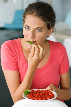 simsearch:6108-05862508,k - Portrait of a woman holding plum tomatoes on a plate Foto de stock - Royalty Free Premium, Número: 6108-05864963