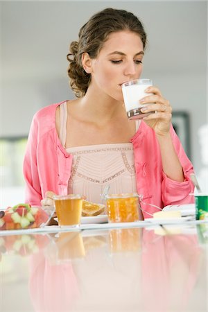 eating bread and butter - Woman having breakfast at a table Stock Photo - Premium Royalty-Free, Code: 6108-05864995