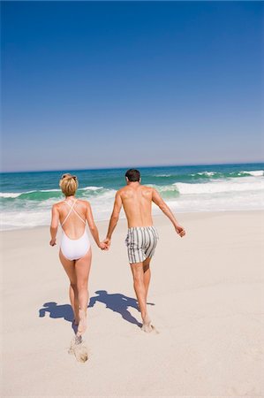 Couple running on the beach Stock Photo - Premium Royalty-Free, Code: 6108-05864907