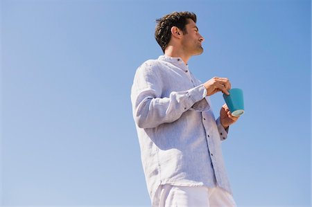 simsearch:6115-07109844,k - Man holding a cup of coffee on the beach Stock Photo - Premium Royalty-Free, Code: 6108-05865060