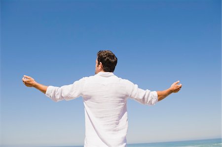 freedom and liberty concepts - Rear view of a man standing on the beach Stock Photo - Premium Royalty-Free, Code: 6108-05865010