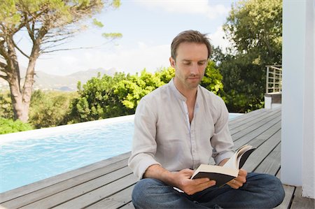 swimming pool housing - Man reading a book Stock Photo - Premium Royalty-Free, Code: 6108-05865029