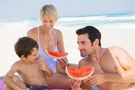 Family enjoying watermelon on the beach Foto de stock - Sin royalties Premium, Código: 6108-05865140