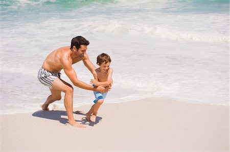 simsearch:6108-05865140,k - Homme qui joue avec son fils sur la plage Photographie de stock - Premium Libres de Droits, Code: 6108-05865187