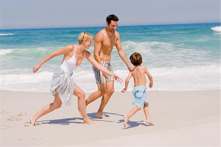 simsearch:6108-05865140,k - Famille jouant sur la plage Photographie de stock - Premium Libres de Droits, Code: 6108-05865185