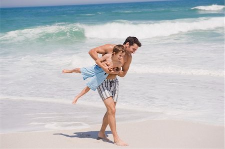 simsearch:6108-05865140,k - Homme qui joue avec son fils sur la plage Photographie de stock - Premium Libres de Droits, Code: 6108-05865192